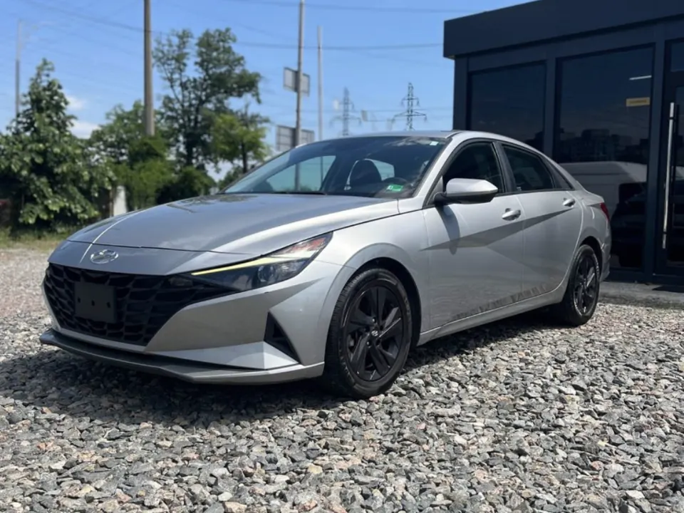 Silver Hyundai Elantra in a gravel yard by a black pavilion